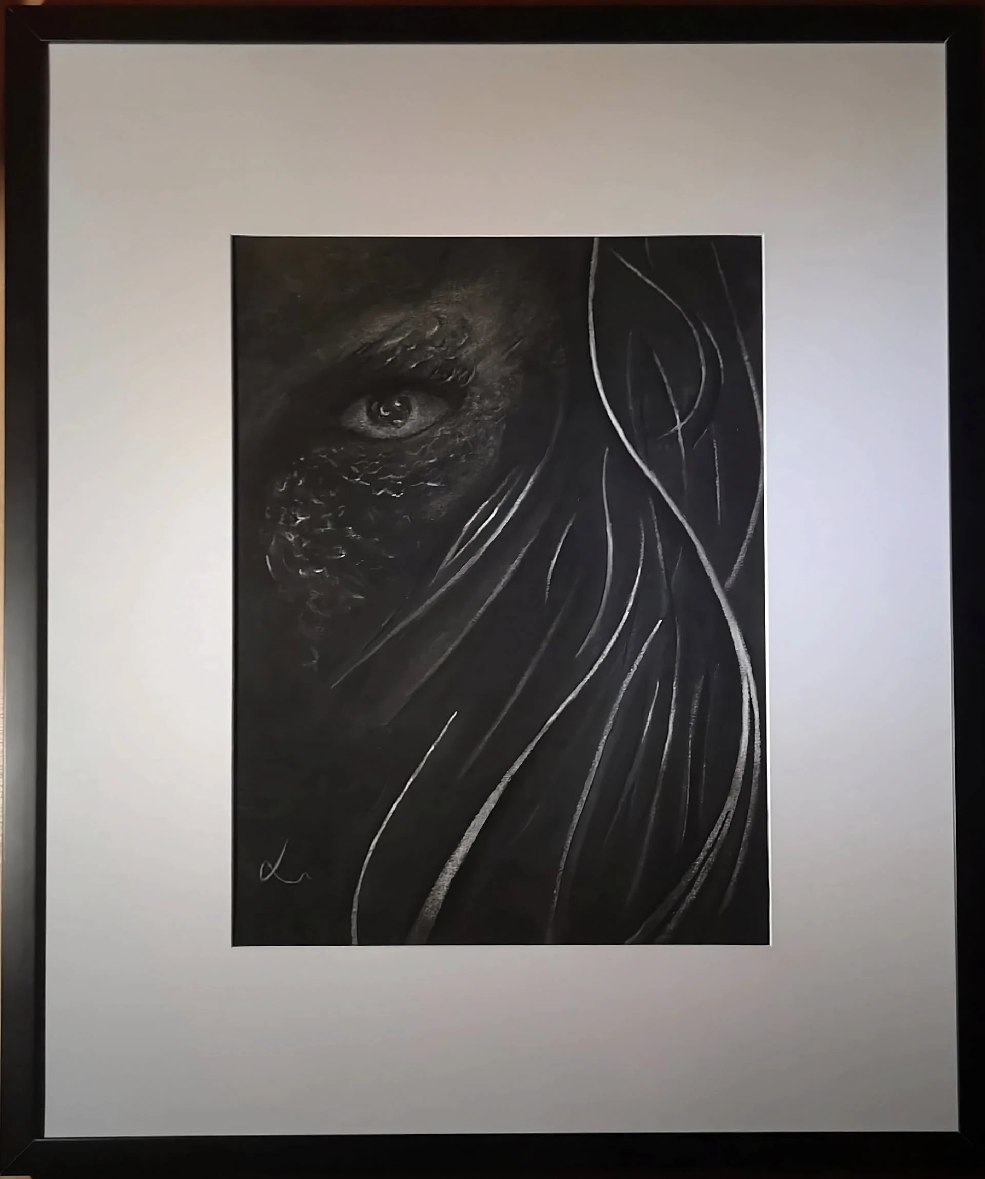 Charcoal drawing of an eye and flowing hair